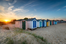 Sunset Over A Row Of Beach Huts At Southwold