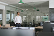 © mavoimages - Young businessman standing in an office looking deep in thought