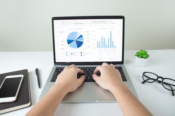 Poster - The hand is using the laptop screen, display the financial graph analysis, the desk screen in the office.