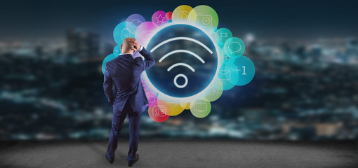 Poster - Businessman in front of a Wifi icon surrounding by colorfull social media icon 3d rendering