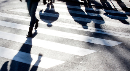 blurry zebra crossing with pedestrians making long shadows