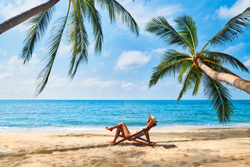 Wall Mural - Young beautiful woman sunbathe and relax on tropical beach