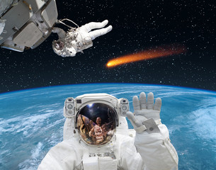 Wall Mural - astronaut waving in front. comet on the background. the elements of this image furnished by nasa.