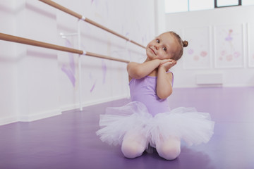 Cute little ballerina dancing at ballet school, copy space. Adorable little girl in ballet outfit practicing at dance class. Children, kids development concept