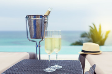 Two glasses of sparkling wine near infinity swimming pool