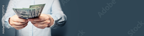 Fotografía Hands giving money US dollars on blue background