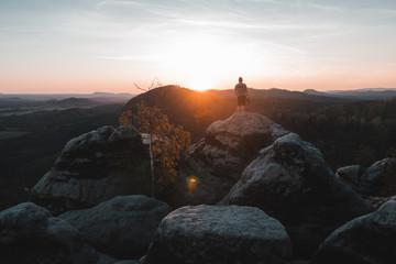 Fototapete - A tourist guy and beautiful morning sunrise of the Mariina Viewpoint, Bohemian Switzerland, National Park Bohemian Switzerland, Czech republic