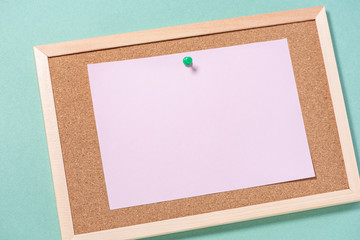 Corkboard for notes with empty sheets on buttons on a green background