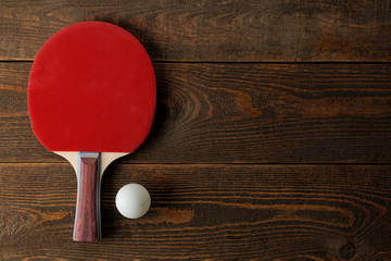 Wall Mural - Two ping pong rackets. Table tennis rackets and a ball on a brown wooden table. sport game. top view