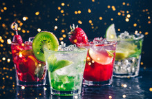 Four Colorful Tasty Alcoholic Cocktails In A Row At The Bar Stand. Luxury Vacation Concept. Toned Image. Festive Holiday Bokeh