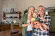 © Rido - Happy grandparents holding smiling grandchild