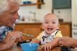 © Rido - Grandfather feeding happy little boy