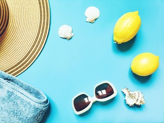 Wall Mural - Beach holidays in Greece. Close-up picture of women's sun hat, towels, sunglasses, lemons and seashells. Flat lay composition photo, mockup, free space for text