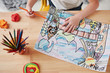 © standret - Particle photo. Cute little girl in art school draws her first paintings by pencils and markers