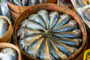 Steamed mackerel sold in the market. Thai steamed mackerel fishes in bamboo basket for sale at the market. Basket of steamed mackerel for sell at the local market .