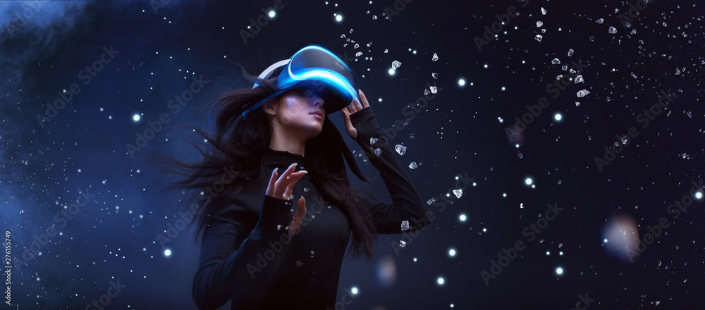Beautiful woman with flowing hair in futuristic dress over dark background. Girl in glasses of virtual reality. Augmented reality, game, future technology concept. VR. - obrazy, fototapety, plakaty 