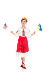 Wall Mural - happy brunette young woman in national Ukrainian costume holding American and Ukrainian flags isolated on white