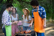 © NDABCREATIVITY - Group of friends having a barbecue party in nature