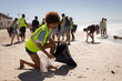 © Wavebreak Media - Female volunteer cleaning beach on a sunny day