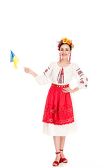 Wall Mural - brunette young woman in national Ukrainian costume holding flag of Ukraine isolated on white