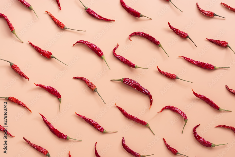 Flat lay dried red chili peppers pattern on a pink peach color background. Top view, flat lay. - obrazy, fototapety, plakaty 