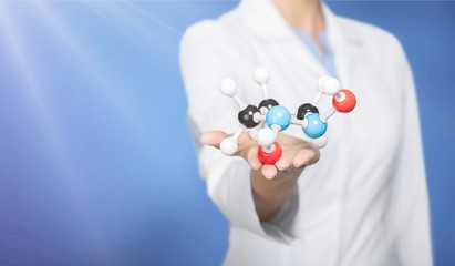 Wall Mural - Close up of Molecular structure model in hand on background