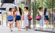 © Syda Productions - sale, consumerism and people concept - happy young women with shopping bags walking along city street
