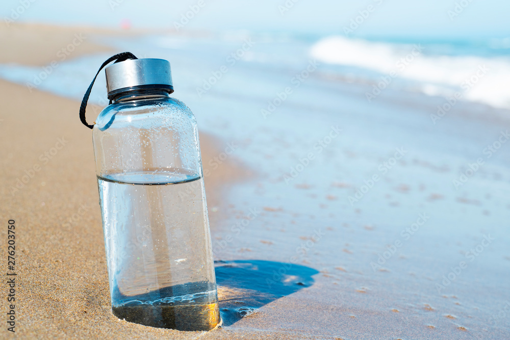reusable water bottle on the beach - obrazy, fototapety, plakaty 