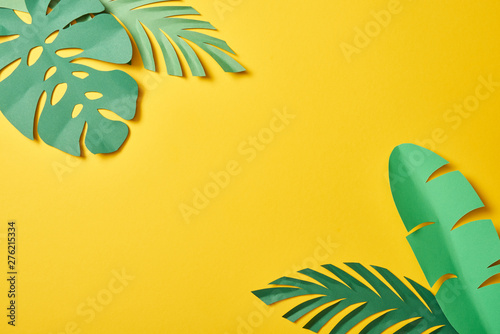 Cuadros en Lienzo top view of paper cut green palm leaves on yellow background with copy space