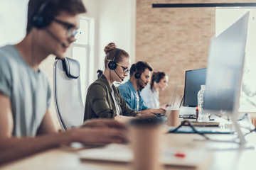 Young woman in glasses is sitting in the call center