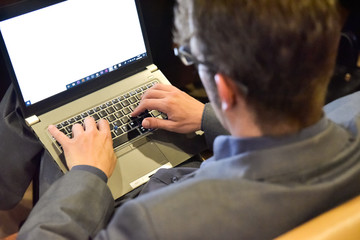 Valencia, Spain - June 20, 2019: Journalist takes notes on his laptop from a lecturer's speech.