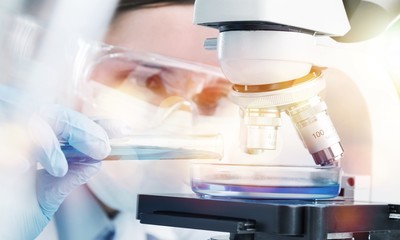 Wall Mural - Young Female Scientist Working with Microscope