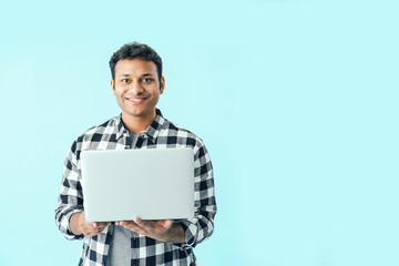 Happy man with laptop on color background