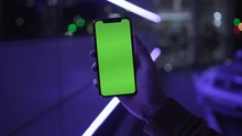 Close Up Man Hands Holding Use Smartphone With Vertical Green Screen On Night City Colorful Background White Car Communication Device Digital Gadget Touchscreen Mobile Close Up
