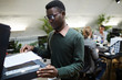 Waist up portrait of African businessman scanning documents while working in office, copy space
