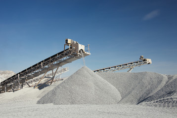 Rock stone crushing machine against a blue sky, close-up. Mining industry. Quarry and mining equipment.