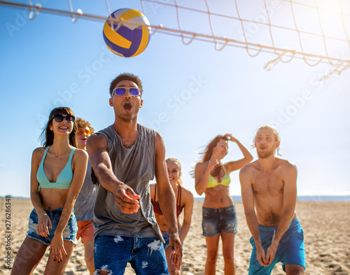 Obrazy piłka plażowa  grupa-przyjaciol-grajaca-w-siatkowke-plazowa-na-plazy