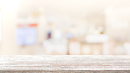 Empty wood table top on blur bokeh cafe and restaurent interior background - can be used for display or montage your products