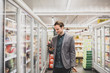 © ReeldealHD images - Man looking at smartphone in a grocery store