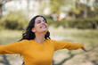 © bnenin - Freedom concept. Young woman spreading hands with joy, in the park.