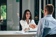 © bnenin - Young businesswoman handshake with a client at modern office.