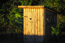 Wooden Outdoor Toilet In The Countryside With A Carved Heart In The Door