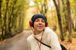© ottochka - Young woman in headphones and in a hat is dancing on the street in autumn