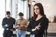 © standret - Attractive woman in black clothes. Group of students in eyewear standing in the learning room at daytime