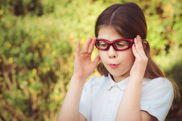 A sporty girl child wearing red prescription sports glasses or goggles, preparing for athletics