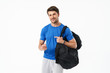 © Drobot Dean - Cheerful optimistic handsome young sports fitness man standing isolated over white wall background holding bag pointing to you.