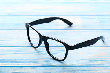 Poster - Eye glasses on blue wooden table