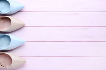 Wall Mural - Different high heel shoes on pink wooden table