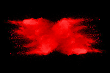 Wall Mural - Explosion of red dust on black background.