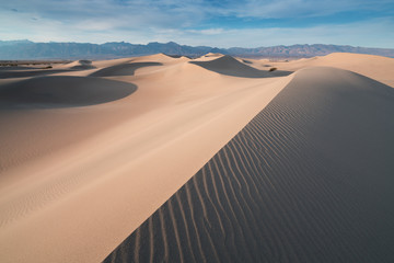 Wall Mural - Early Morning Sunlight Over Sand Dunes And Mountains At Mesquite flat dunes, Death Valley National Park, California USA Stovepipe Wells sand dunes, very nice structures in sand Beautiful background